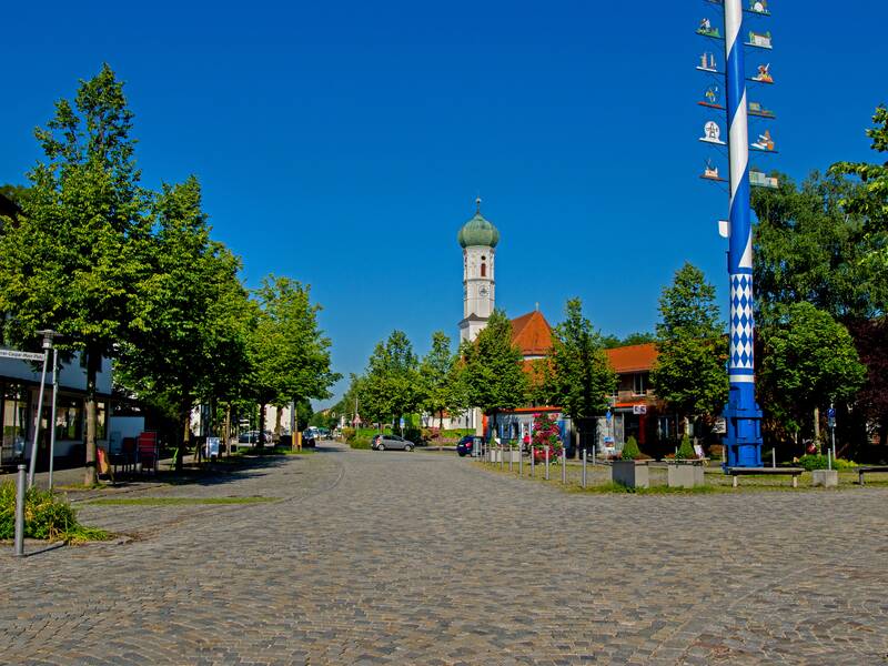 Man erkennt die Ortsmitte von Kirchheim. Im Vordergrund sieht man den Maibaum, im Hintergrund die Kirche.